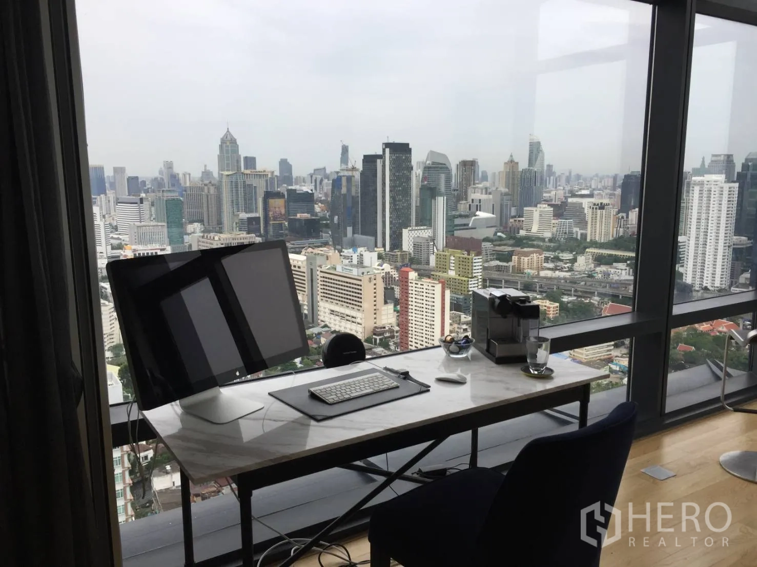 公寓 出租或出售在Ratchathewi, Bangkok - 落地窗旁的家用办公桌，眺望曼谷城市景色。
