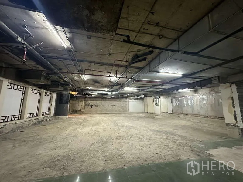 Retail Space for rent - Spacious shop interior with raw concrete walls and open ceiling services providing a shell condition.