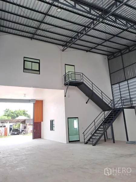 Warehouse for rent in Lam Luk Ka, Pathum Thani - Street-facing modern warehouse exterior with canopy and secure roller shutter.
