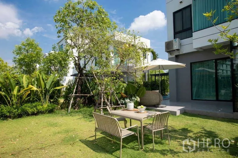 独立式住宅 出租或出售在Lat Krabang, Bangkok - 草坪花园，树荫下的户外餐桌椅，毗邻住宅。