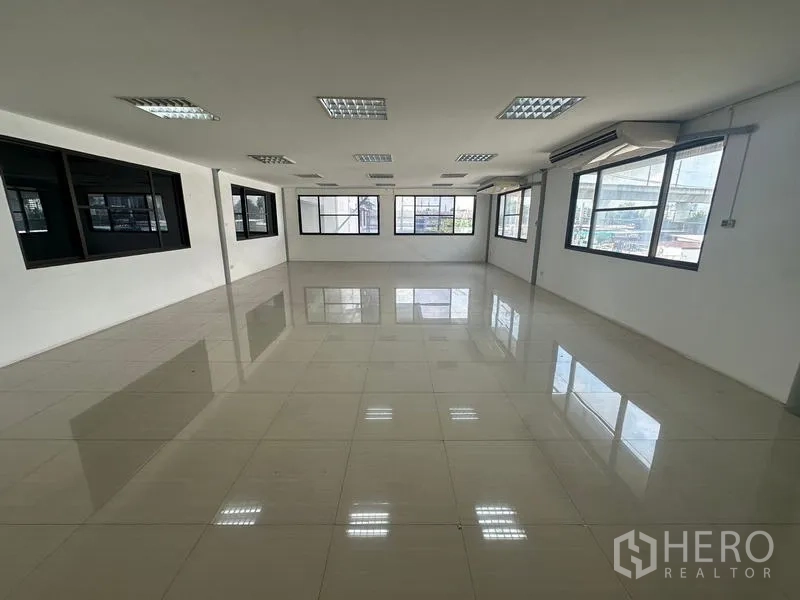Warehouse for rent in Suan Luang, Bangkok - Bright open-plan office with large windows and polished tile floor.