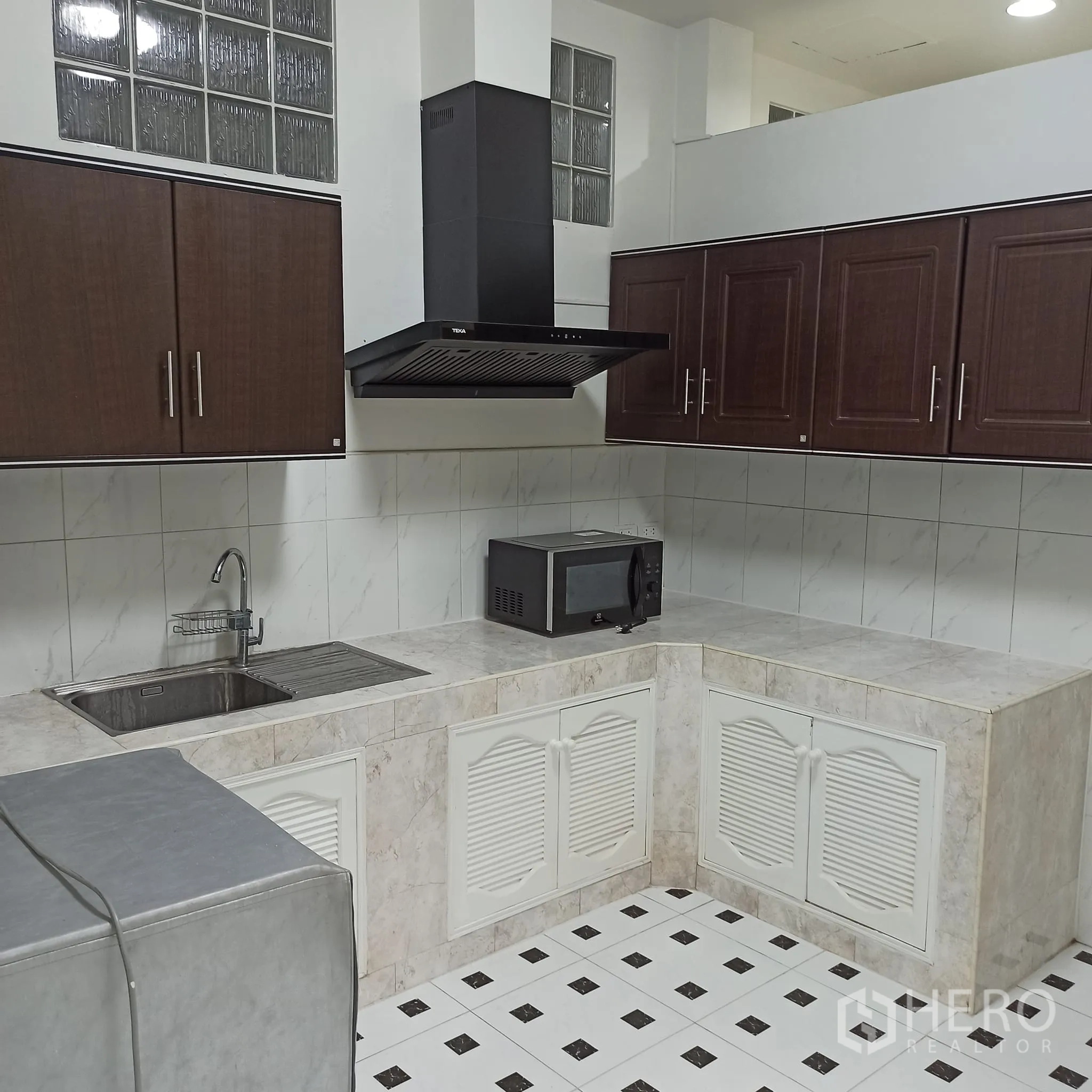 Townhouse for rent in Wang Thonglang, Bangkok - Fitted Thai kitchen with cabinets, range hood and sink.