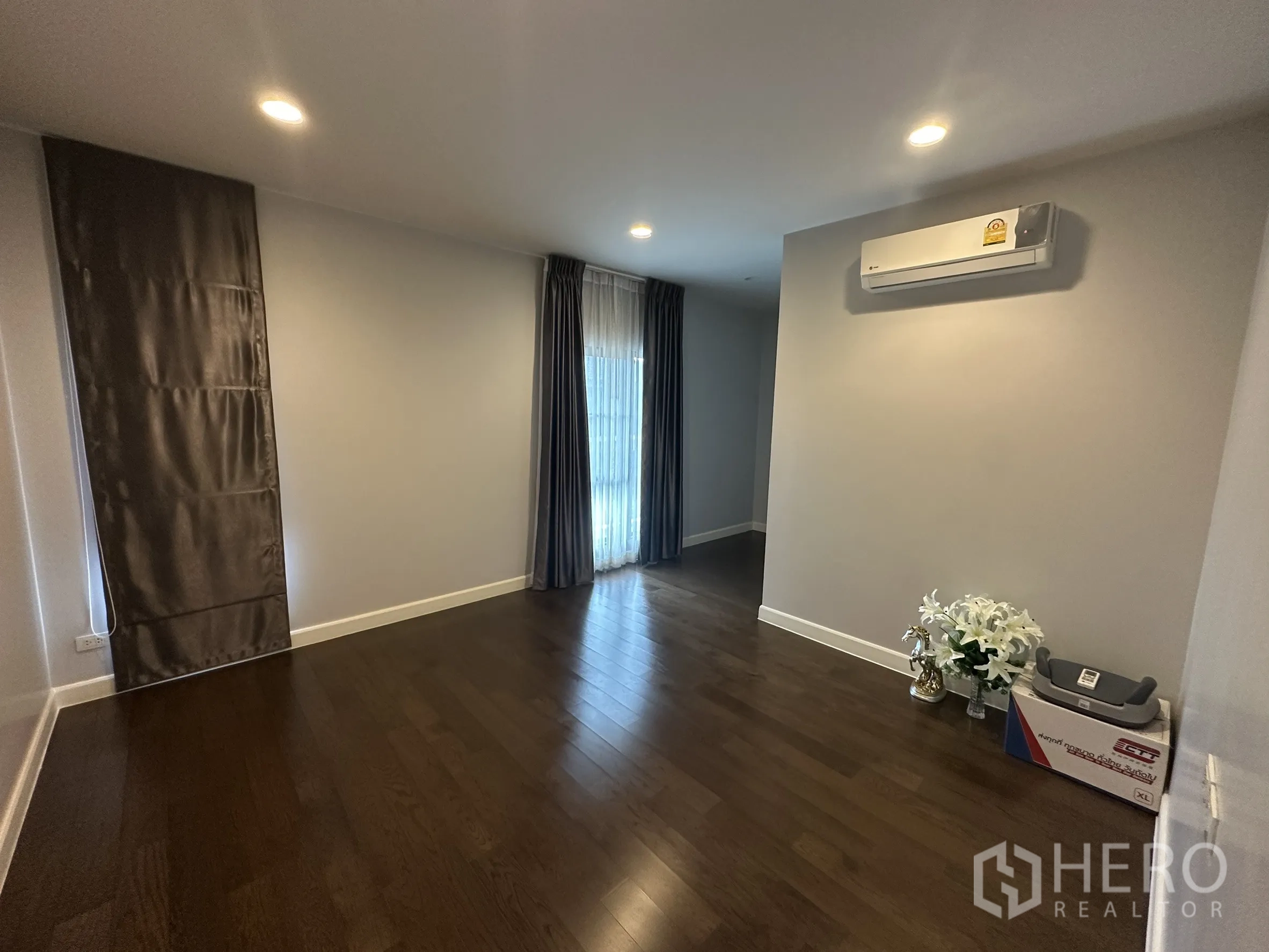 Detached House for rent in Lam Luk Ka, Pathum Thani - Empty multipurpose room with AC and full-height curtains.
