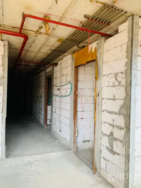 带办公室的家 出租 - 毛坯走廊，砌块墙与门框，顶部红色消防管线清晰可见。