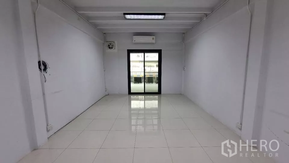 Townhouse for rent in Huai Khwang, Bangkok - Bright room with sliding glass door, air conditioner and white tiled flooring.