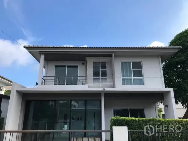 บ้าน ให้เช่าในBang Na, Bangkok - หน้าบ้านเดี่ยวสองชั้นสไตล์โมเดิร์น มีระเบียง ฉากบังสายตา และประตูกระจกบานใหญ่ย่านบางนา