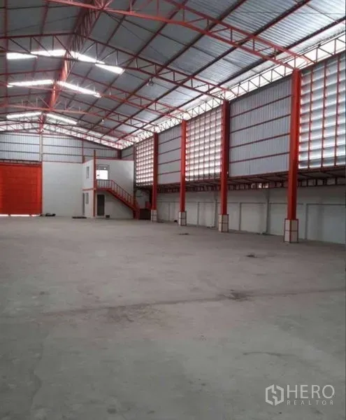Warehouse for rent in Bang Phli, Samut Prakan - Interior view showing large rolling shutter and two-storey office with staircase