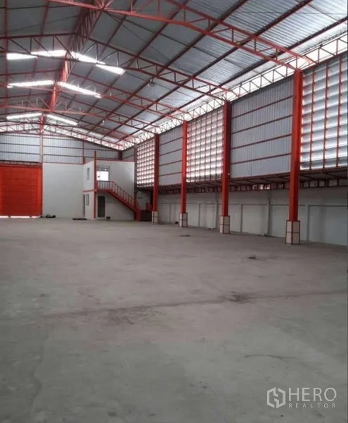 Warehouse for rent in Bang Phli, Samut Prakan - Interior view showing large rolling shutter and two-storey office with staircase