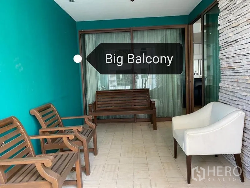 Condominium for rent - Spacious covered balcony with seating, teal accent wall and sliding glass doors