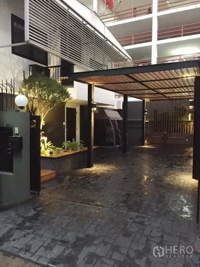 Detached House for rent in Watthana, Bangkok - Modern house entrance with covered carport, landscaped planter and warm exterior lighting in Ekkamai, Bangkok.