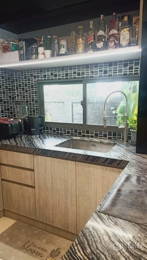 Detached House for rent or sale in Khan Na Yao, Bangkok - Kitchen corner with under‑mount sink, pull‑down faucet and stone countertops by window.