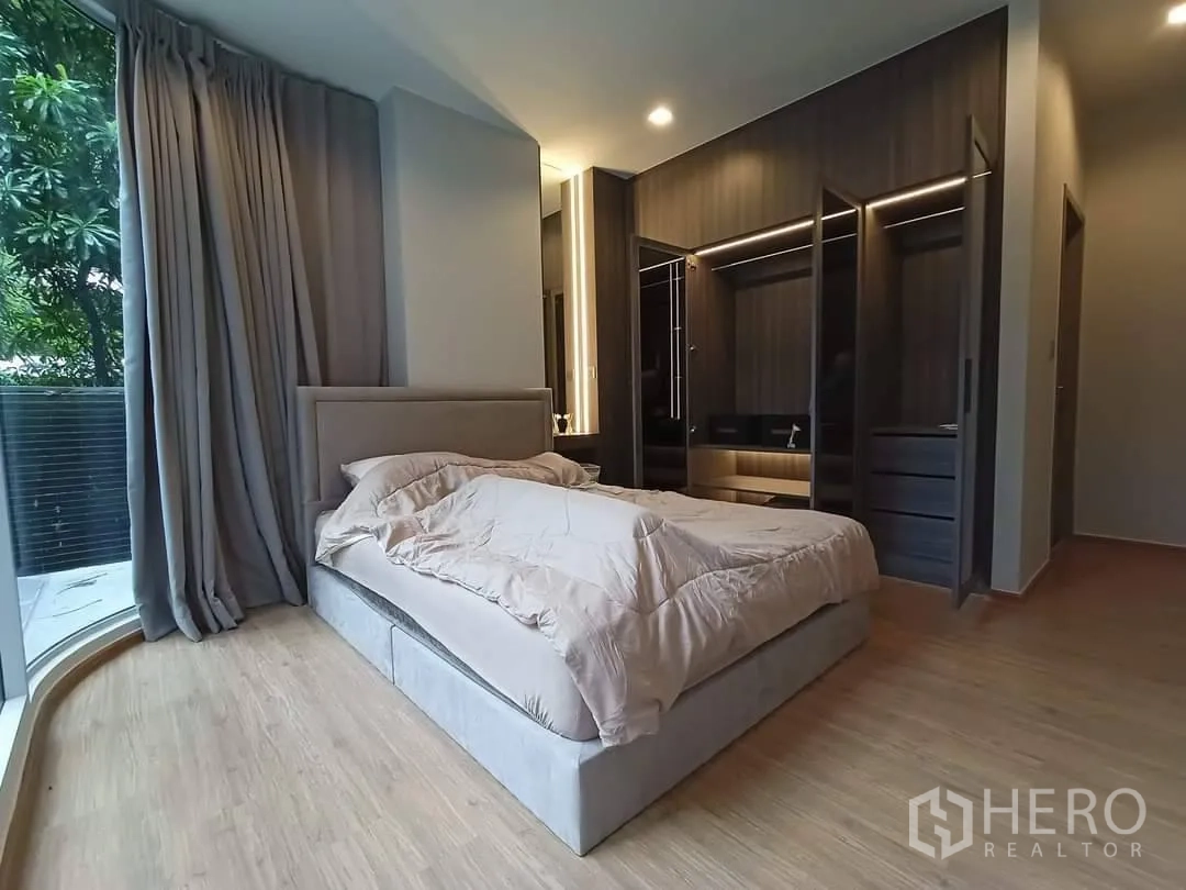 คอนโด for rent in Watthana, Bangkok - ห้องนอนหลักตู้เสื้อผ้าบิวท์อิน หน้าต่างโค้งเห็นวิวต้นไม้