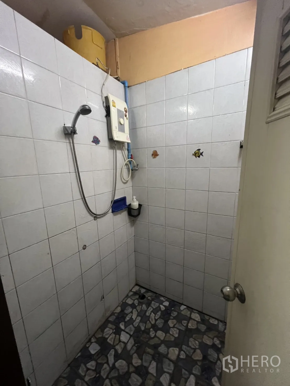 店屋 出租在Khlong Toei, Bangkok - 淋浴区带电热水器与浅色墙砖。