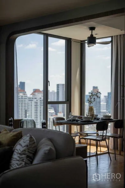 Condominium for sale in Khlong Toei, Bangkok - Corner dining nook by floor-to-ceiling windows overlooking the Thonglor skyline.