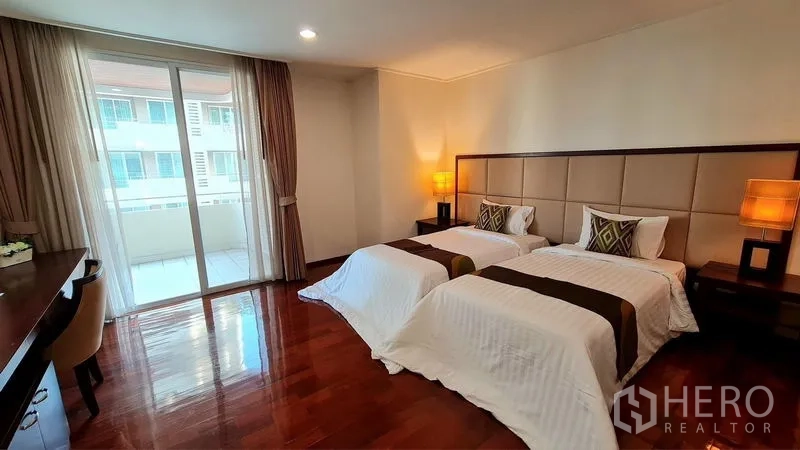 คอนโด ให้เช่าในWatthana, Bangkok - ห้องนอนเตียงคู่ พื้นไม้ โต๊ะเขียนหนังสือ และประตูเลื่อนออกสู่ระเบียง