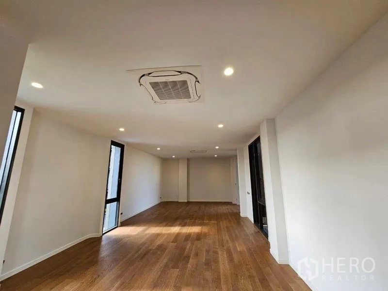 Detached House for rent in Wang Thonglang, Bangkok - Expansive room with wood flooring and ceiling cassette air conditioner.