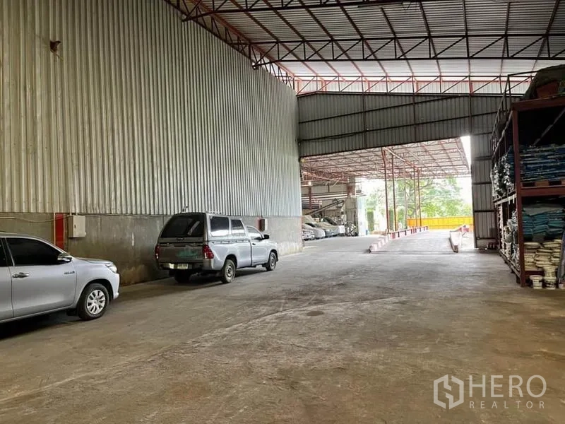 คลังสินค้า ขายในLam Luk Ka, Pathum Thani - ทางเชื่อมภายในเปิดสู่ลานด้านนอก ด้านขวามีชั้นวางสินค้าและรถจอดริมผนัง