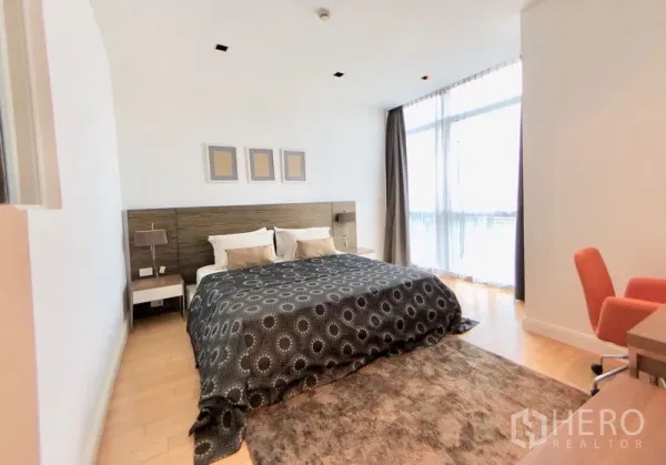 Condominium for rent in Pathum Wan, Bangkok - Spacious master bedroom with king bed, floor‑to‑ceiling windows, desk and soft area rug.