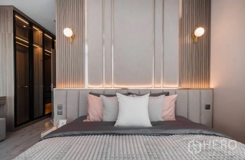 Condominium for rent in Watthana, Bangkok - Master bedroom with padded headboard, wall sconces and built-in wardrobe.