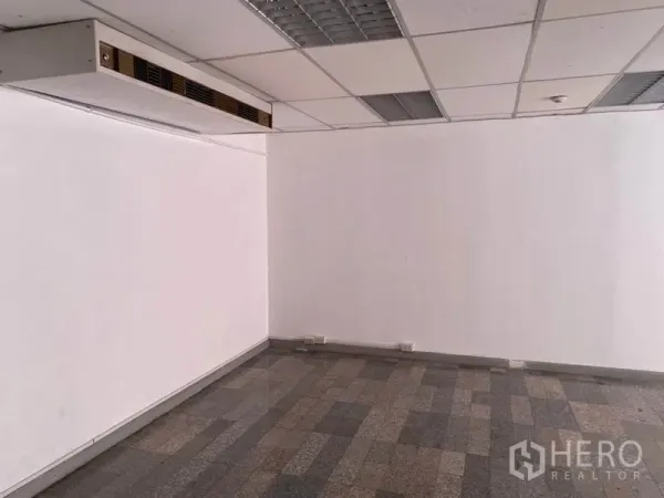 Office Space for rent in Khlong Toei, Bangkok - Empty office room with a suspended ceiling, ducted air-conditioning and gray tile flooring.