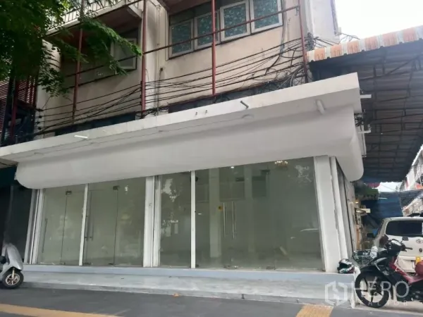 Retail Space for rent in Khlong Toei, Bangkok - Ground-floor retail facade with wide glass storefront and white awning on a Bangkok street.