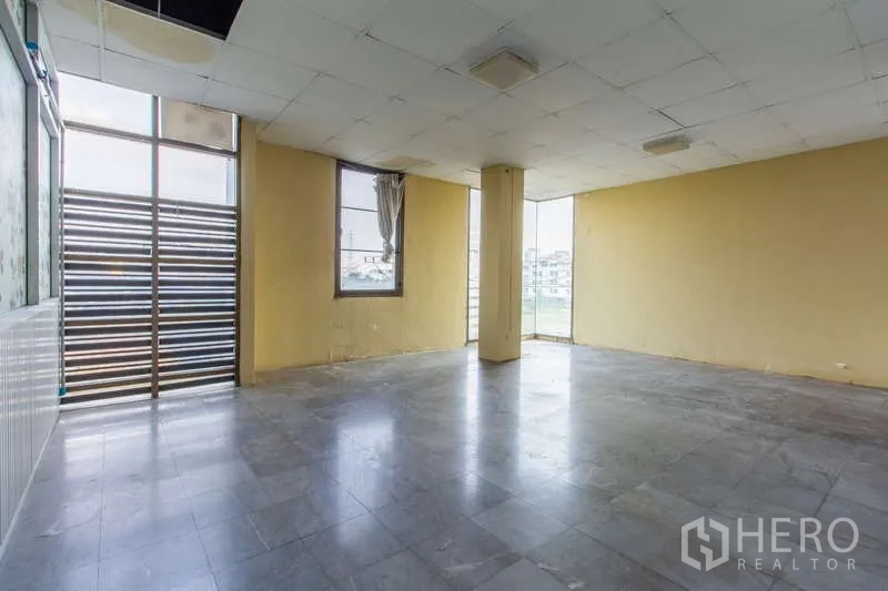 สำนักงาน ให้เช่าหรือขายในHuai Khwang, Bangkok - ห้องโล่งผนังสีเหลือง หน้าต่าง และประตูลูกฟักระแนงไปยังระเบียง