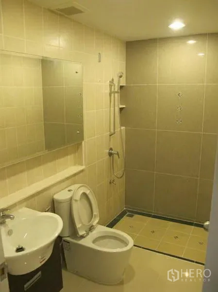 联排别墅 出租或出售在Wang Thonglang, Bangkok - 全瓷砖浴室，步入式淋浴、坐便器、洗手盆与镜子。