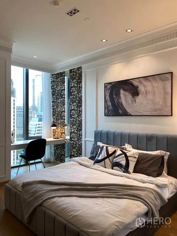 公寓 for rent in Pathum Wan, Bangkok - 卧室设软包床头与抽象画，窗边书桌和花纹墙板相映成趣。