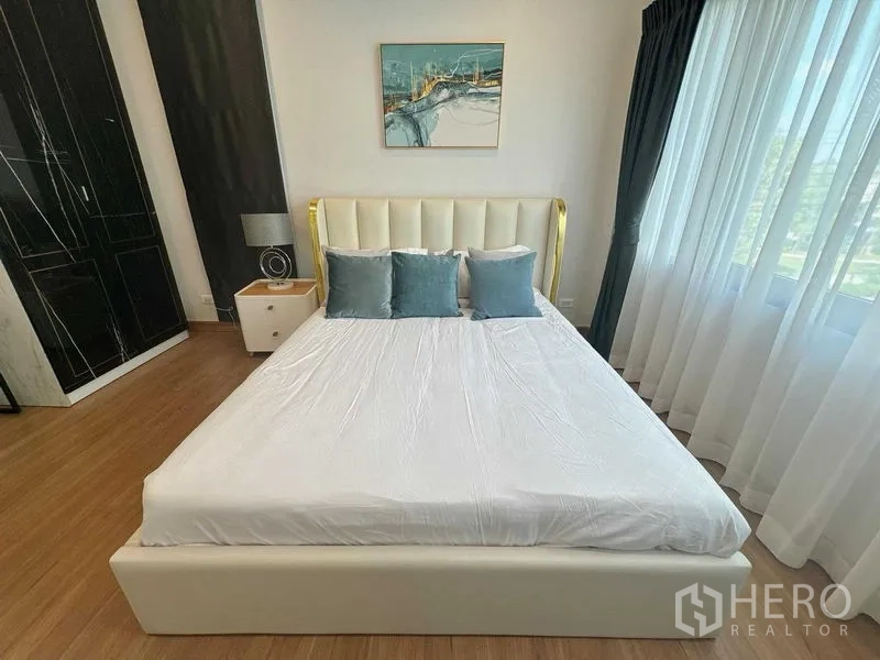 Detached House for rent or sale - Guest bedroom with white bedframe, teal pillows, side table and large wardrobe by the window.
