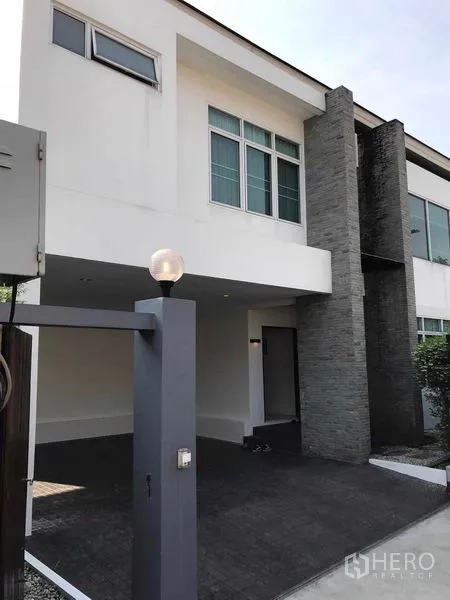 Detached House for sale in Wang Thonglang, Bangkok - Modern two-storey house exterior with stone feature wall and covered carport