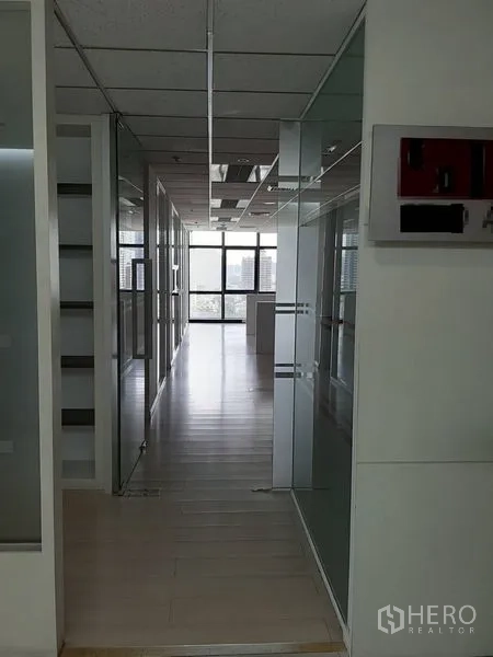 Office Space for rent in Bang Rak, Bangkok - Open-plan office with built-in workstations and city views through large windows.