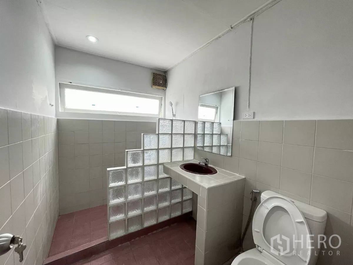 Home Office for rent in Din Daeng, Bangkok - Bathroom with glass‑block shower divider and built‑in counter with a burgundy basin.