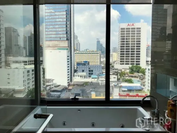 Condominium for rent in Bang Rak, Bangkok - Bathtub set against a large picture window overlooking Bangkok skyline.