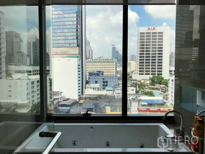 Condominium for rent in Bang Rak, Bangkok - Bathtub set against a large picture window overlooking Bangkok skyline.