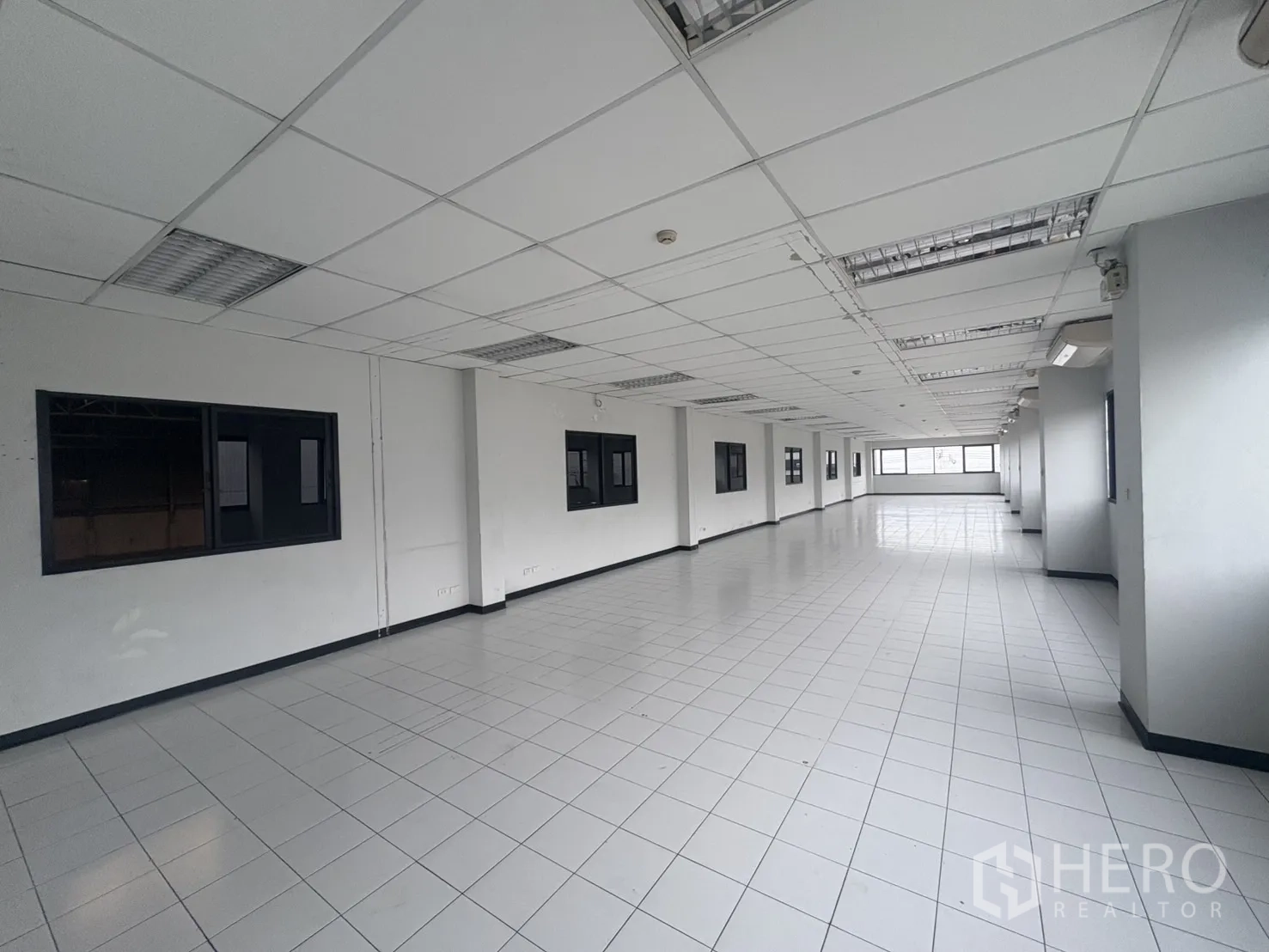 Factory for rent or sale in Samut Prakan - Bright office room with wide exterior windows and air‑conditioning.