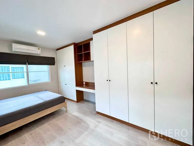 独立式住宅 出租或出售在Prawet, Bangkok - 卧室另一角度，整面到顶衣柜与工作台。