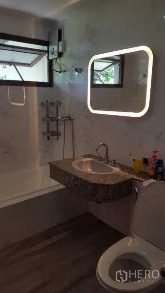 独立式住宅 出租在Bang Phli, Samut Prakan - 浴室配发光镜、仿石材墙、浴缸与现代洁具。