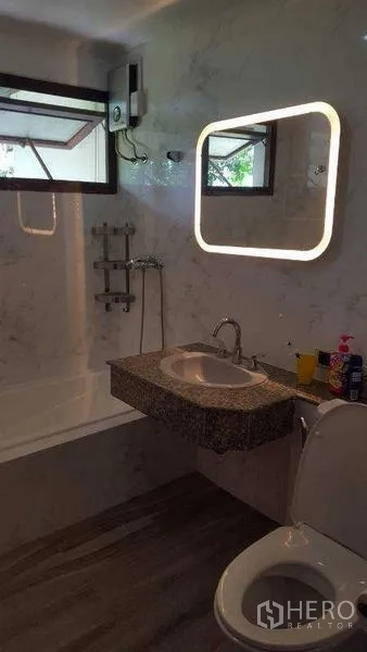 独立式住宅 出租在Bang Phli, Samut Prakan - 浴室配发光镜、仿石材墙、浴缸与现代洁具。