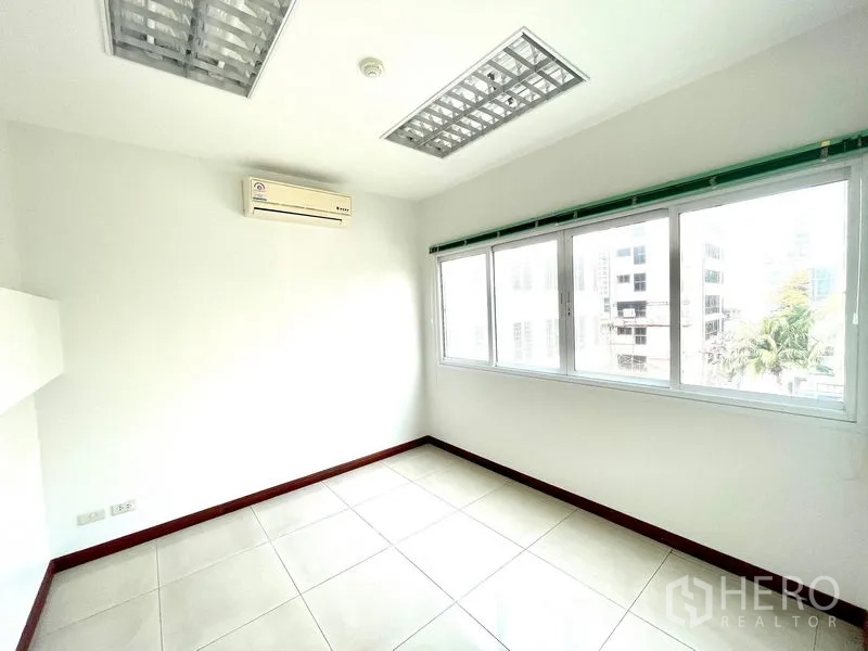 Office Space for rent in Bang Rak, Bangkok - Bright private office with large windows, tiled floors and wall‑mounted air conditioner in Sathorn.