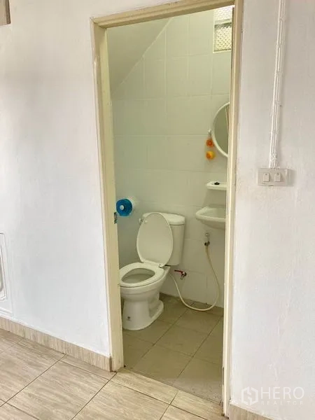 Warehouse for rent in Bang Phli, Samut Prakan - Clean bathroom with toilet, sink and white tiled walls.