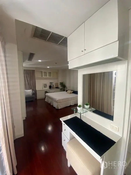 公寓 出租在Pathum Wan, Bangkok - 更衣梳妆区，带镜子与凳子，通向宽敞卧室。