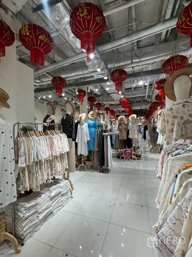 店屋 出租在Samphanthawong, Bangkok - 零售楼层，衣架成排，红灯笼与裸露风管顶。