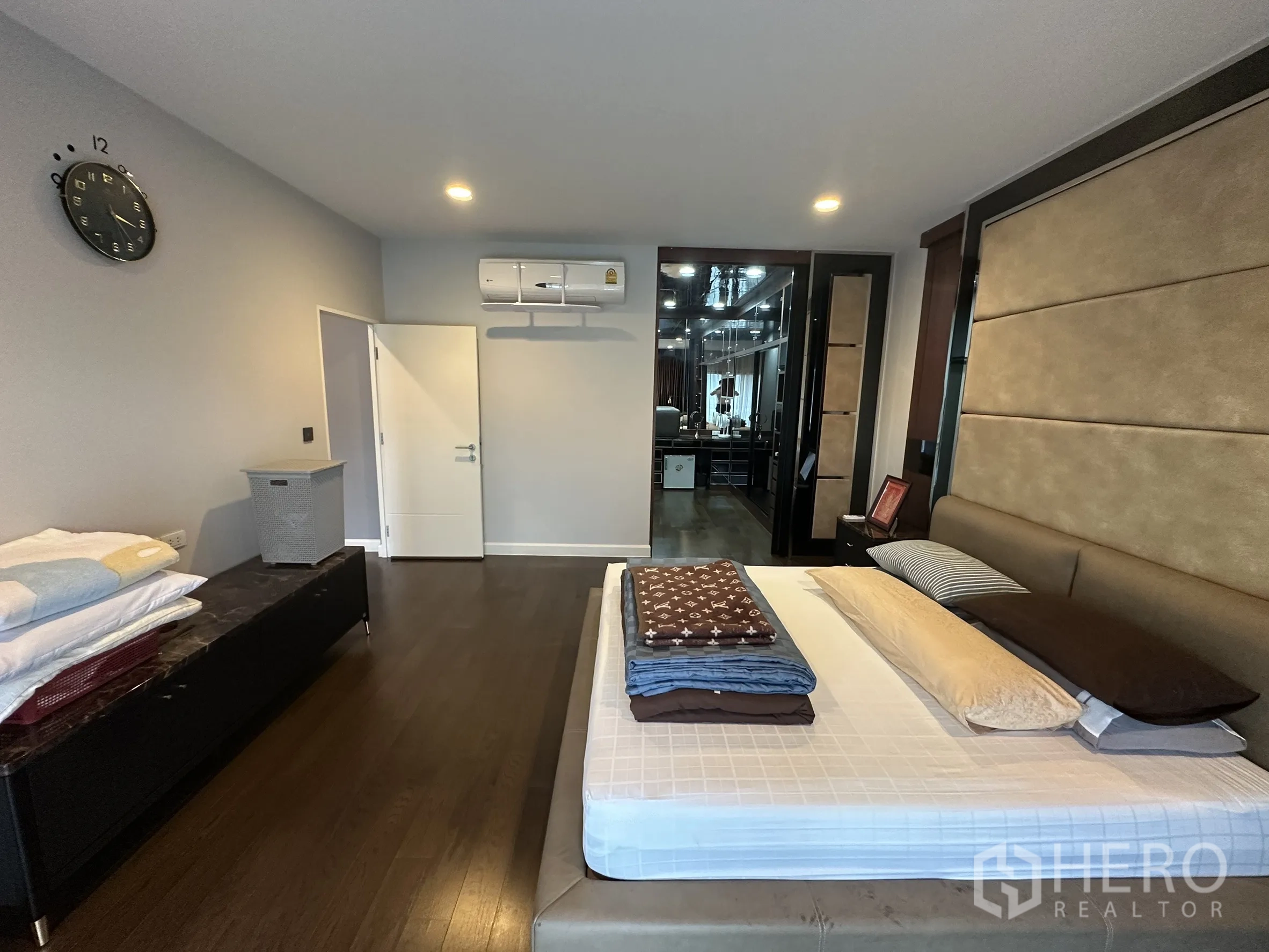 Detached House for rent in Lam Luk Ka, Pathum Thani - Master bedroom wide view with padded feature wall and seating.