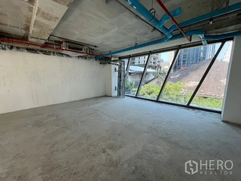 Retail Space for rent in Pathum Wan, Bangkok - Spacious open-plan shell with slanted glazing and urban views.