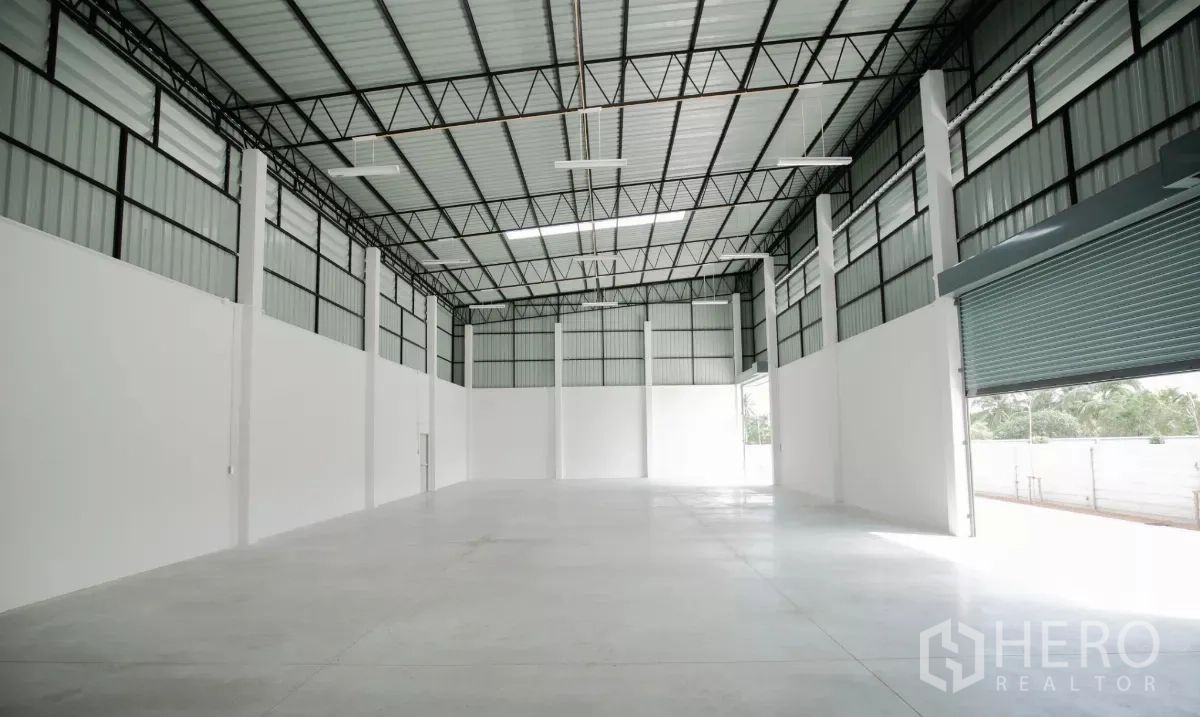 工厂 出租或出售在Nakhon Pathom - 开阔生产车间，成列立柱、保温屋顶与卷闸门。