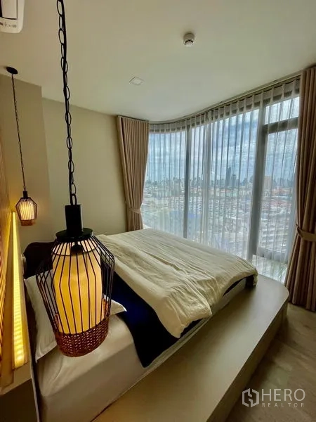 Condominium for sale - Corner master bedroom with floor-to-ceiling windows, sheer curtains and panoramic city view.