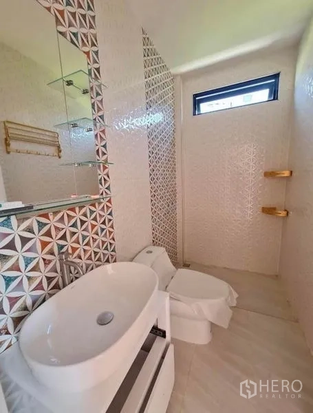 Detached House for sale in Sai Mai, Bangkok - Bright bathroom with geometric tiles, round basin, and gold shelves.