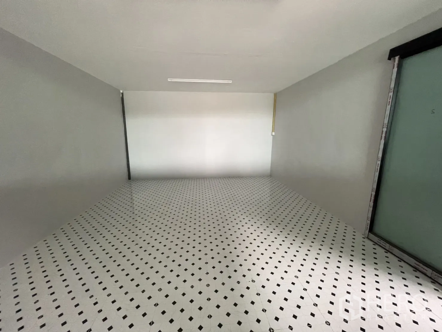 Factory for rent in Khlong Luang, Pathum Thani - Small internal office room with white patterned tile floor and a fluorescent light.