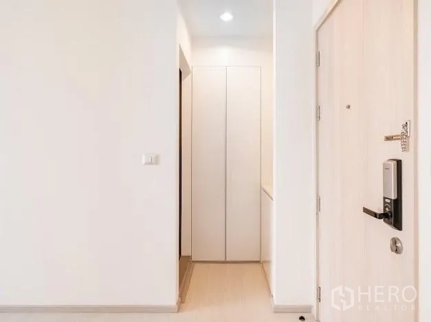 Condominium for sale in Khlong Toei, Bangkok - Entrance foyer featuring a tall storage cabinet and secure digital door lock.