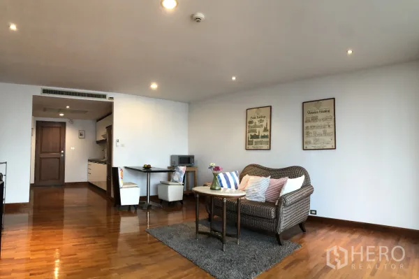 Condominium for rent in Khlong Toei, Bangkok - Open-plan living and dining area with compact kitchenette, small dining set and recessed lighting.